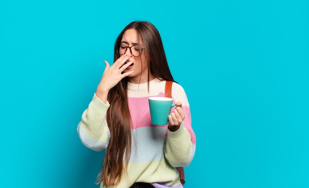 Jeune jolie femme étudiante avec une tasse de café