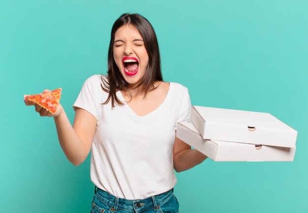 Jeune jolie femme expression en colère et tenant une pizza