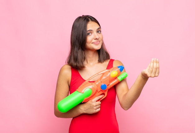 Jeune jolie femme faisant un geste de capice ou d'argent, vous disant de payer vos dettes !. concept d'été