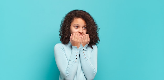 Jeune jolie femme faisant des gestes sur un mur de couleur