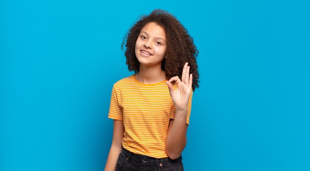 Jeune jolie femme faisant des gestes sur un mur de couleur