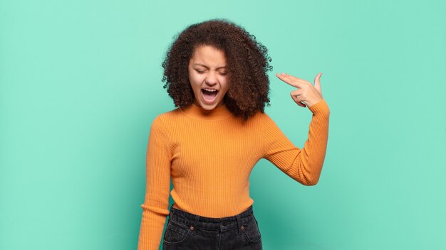 Jeune jolie femme faisant des gestes sur un mur de couleur