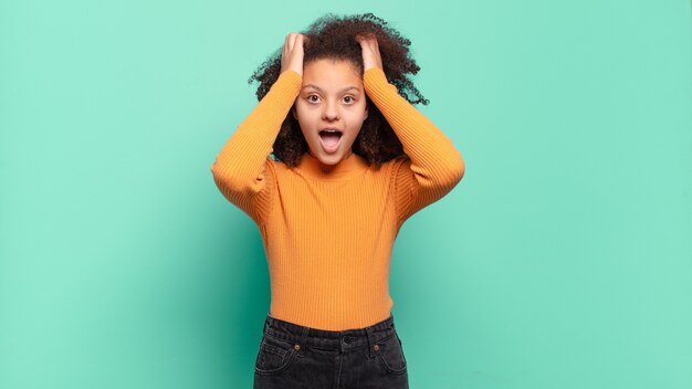 Photo jeune jolie femme faisant des gestes sur un mur de couleur