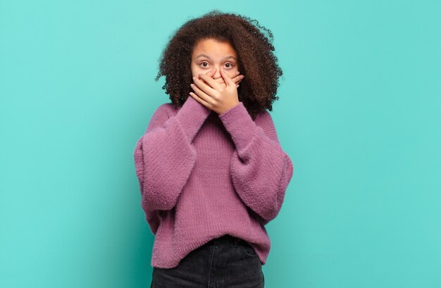 Jeune jolie femme faisant des gestes sur un mur de couleur