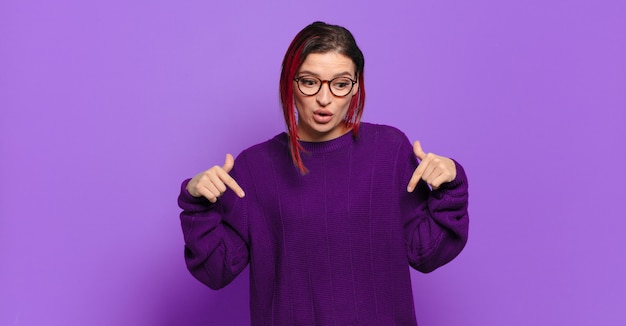 Jeune jolie femme faisant des gestes sur un mur de couleur