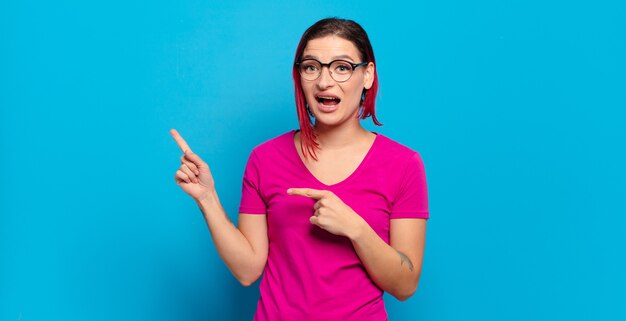 Jeune jolie femme faisant des gestes sur un mur de couleur