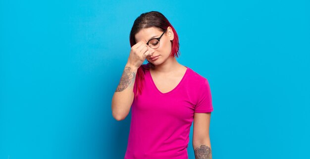 Jeune jolie femme faisant des gestes sur un mur de couleur