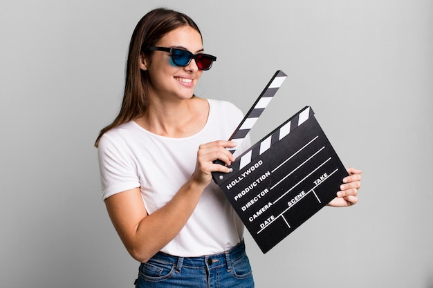 Jeune jolie femme avec un film de clapet de cinéma ou un concept de film