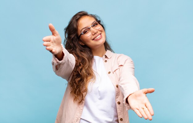 jeune jolie femme sur fond bleu avec des lunettes