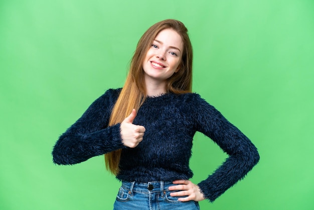 Jeune jolie femme sur fond isolé chroma key donnant un geste du pouce levé