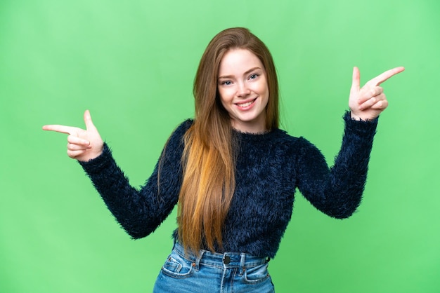 Jeune jolie femme sur fond isolé chroma key pointant le doigt vers les latéraux et heureux