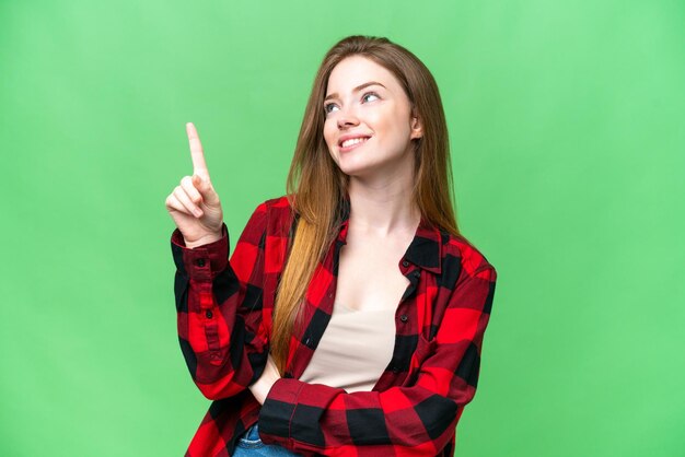 Jeune jolie femme sur fond isolé chroma key pointant vers le haut une excellente idée