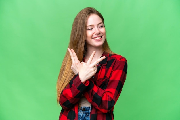 Jeune jolie femme sur fond isolé chroma key souriant et montrant le signe de la victoire