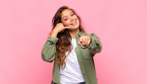 jeune jolie femme avec un grand sourire amical et insouciant, à la recherche positive, détendue et heureuse, effrayante. concept de maison