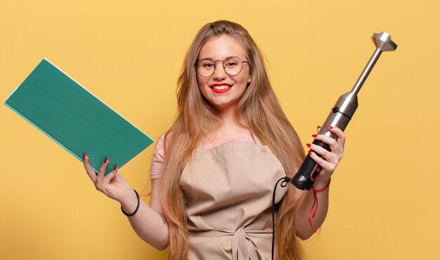 Jeune jolie femme heureuse et surprise concept de mélangeur de boulanger d'expression