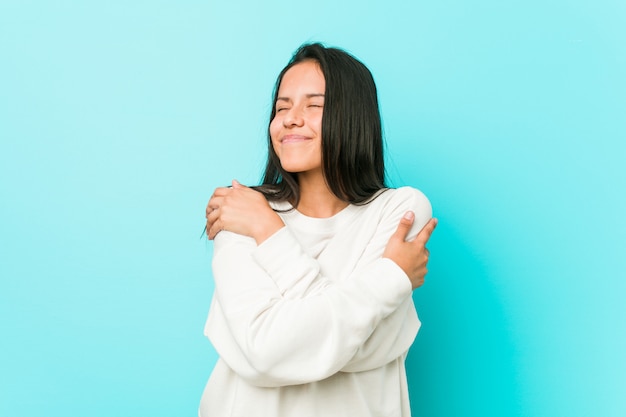 Jeune jolie femme hispanique étreint, souriant insouciant et heureux.