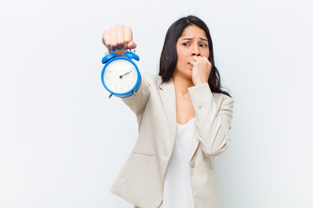 Jeune jolie femme hispanique avec une horloge