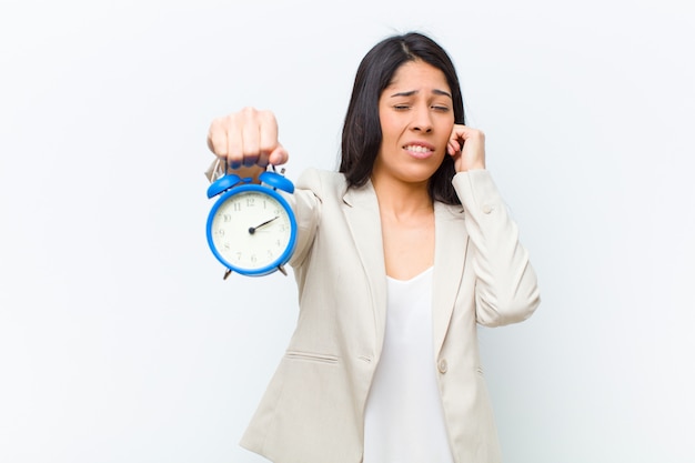 Jeune jolie femme hispanique avec une horloge