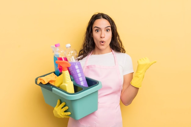 Jeune jolie femme hispanique qui a l'air étonnée de l'incrédulité des travaux ménagers un concept de produits propres