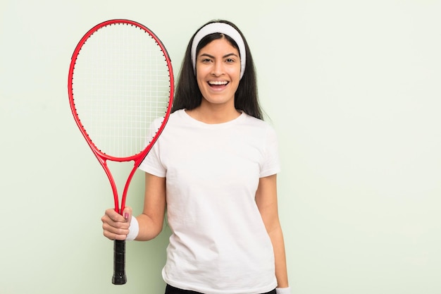 jeune jolie femme hispanique qui a l'air heureuse et agréablement surprise. notion de tennis