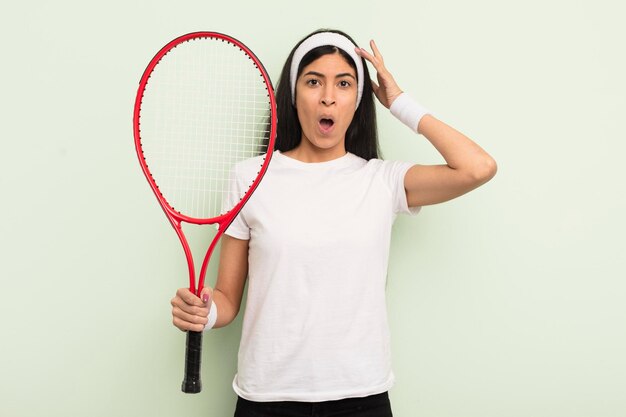 Jeune jolie femme hispanique à la recherche d'un concept de tennis étonné et surpris heureux