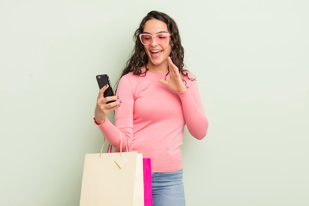 Jeune jolie femme hispanique avec des sacs à provisions