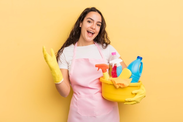 Jeune jolie femme hispanique se sentant heureuse surprise de réaliser une solution ou une idée de travaux ménagers un concept de produits propres