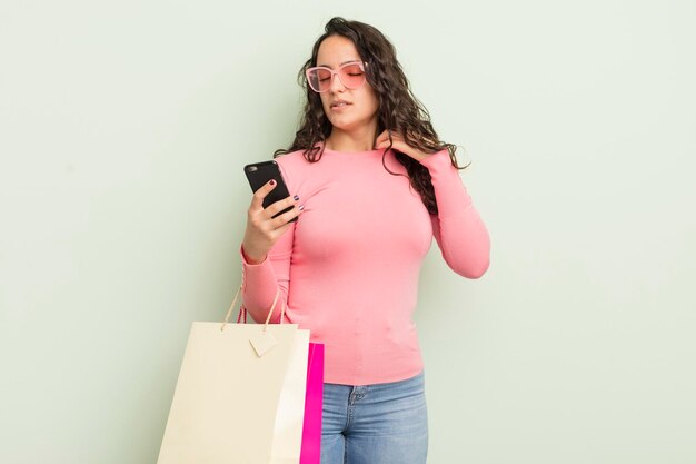 Jeune jolie femme hispanique se sentant stressée anxieuse fatiguée et frustrée concept de sacs à provisions