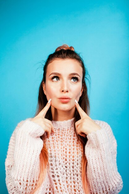 jeune jolie femme joyeuse heureuse souriante posant sur fond bleu