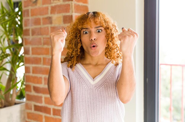 Jeune jolie femme latine aux cheveux roux dans une nouvelle maison cool