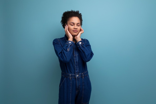 Jeune jolie femme latine brune aux cheveux afro attachés en queue de cheval vêtue d'un élégant bleu