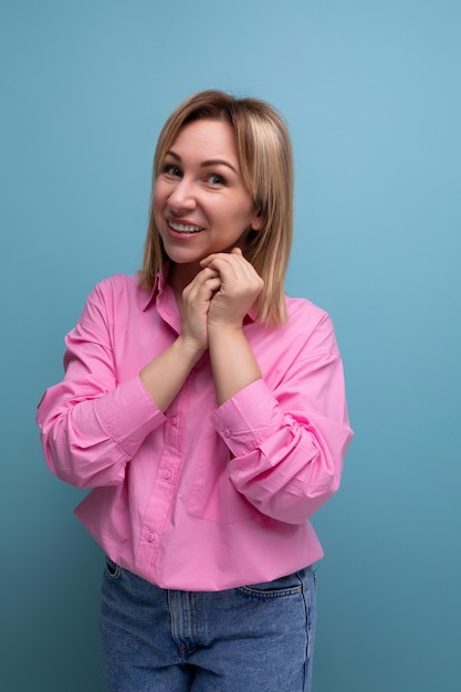 Jeune jolie femme leader carriériste blonde aux cheveux mi-longs dans un chemisier rose