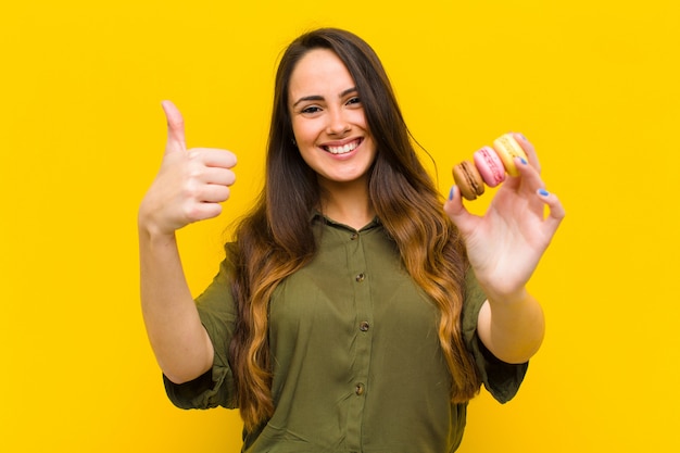 Jeune jolie femme avec des macarons.