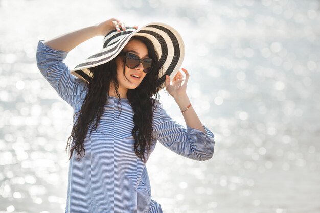 Jeune jolie femme marchant sur une plage. Jolie fille adulte près de l'eau relaxante. Belle femme sur la mer