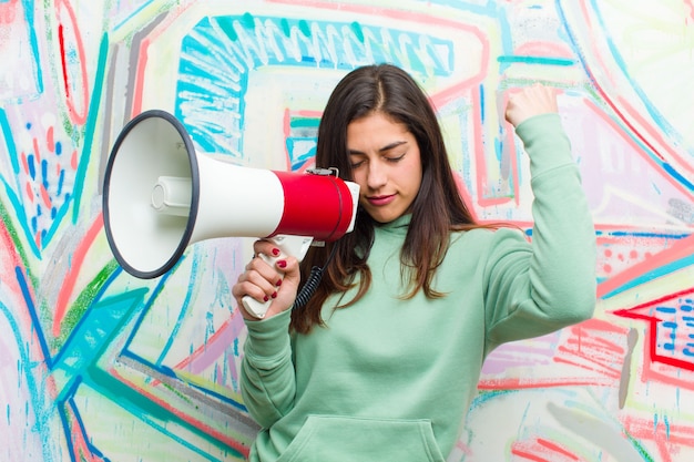 Jeune Jolie Femme Avec Un Mégaphone Contre Le Mur De Graffitis