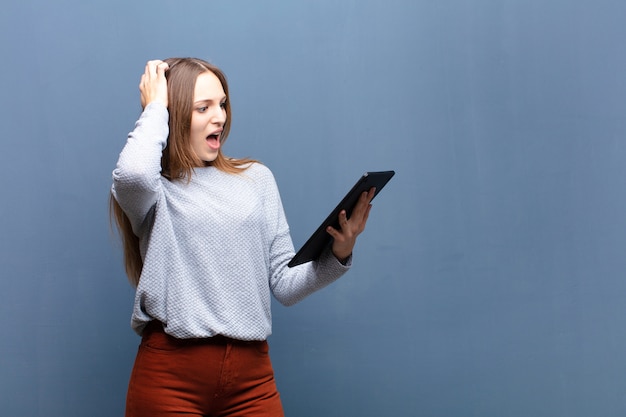 Jeune Jolie Femme Avec Un Mur De Tablette Bleue Avec Une Surface