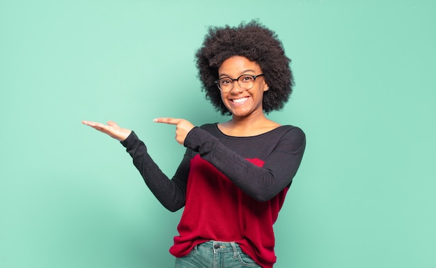 jeune jolie femme noire montrant un produit