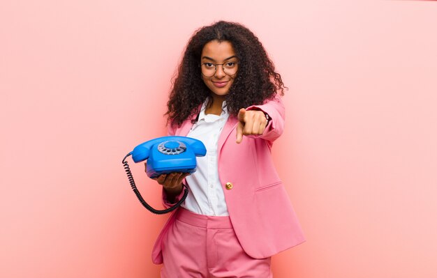 Jeune Jolie Femme Noire Avec Un Téléphone Vintage Contre Le Mur Rose