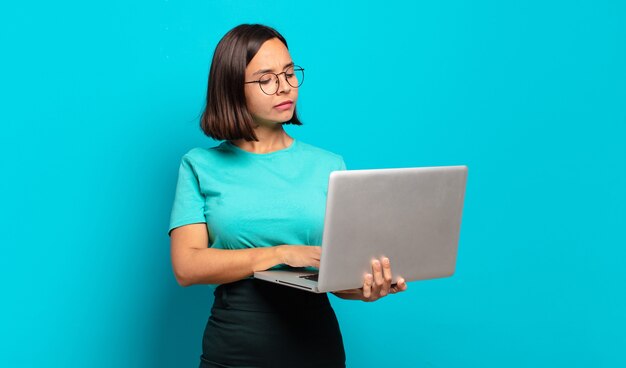 Jeune jolie femme avec un ordinateur portable