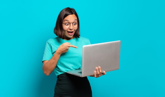 Jeune jolie femme avec un ordinateur portable