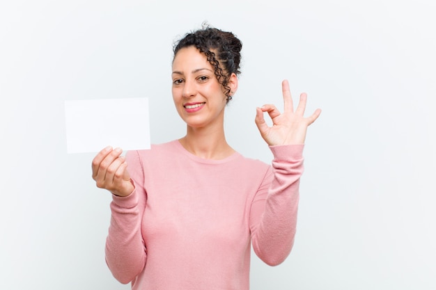 Jeune jolie femme avec une pancarte mur blanc