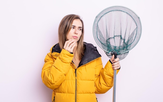 Jeune jolie femme pensant, se sentant douteuse et confuse. notion de pêcheur