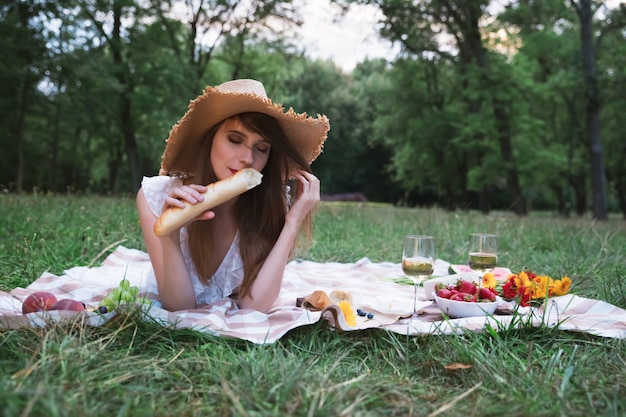 Jeune jolie femme sur un pique-nique dans un parc de la ville