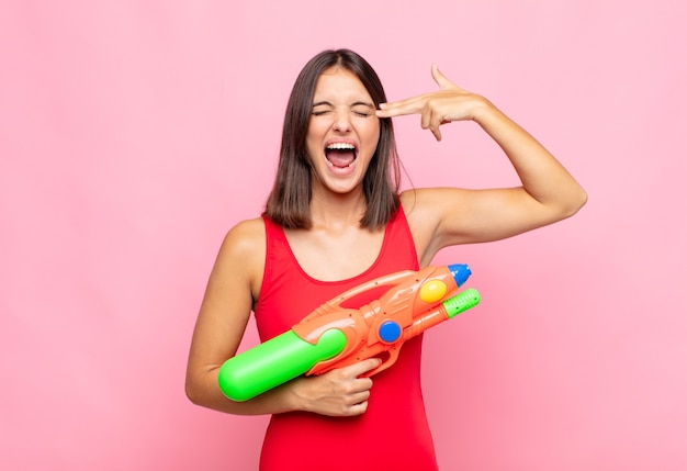 jeune jolie femme avec un pistolet à eau