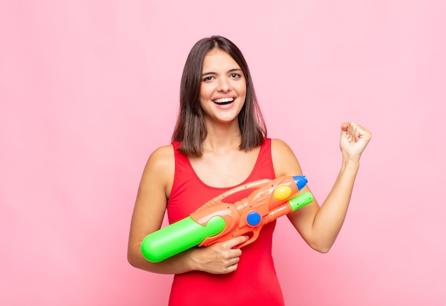 jeune jolie femme avec un pistolet à eau