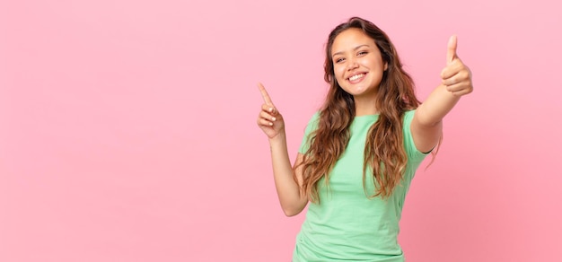 Photo jeune jolie femme et pointant vers l'espace de copie