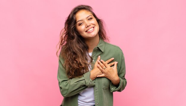 jeune jolie femme posant contre le mur coloré