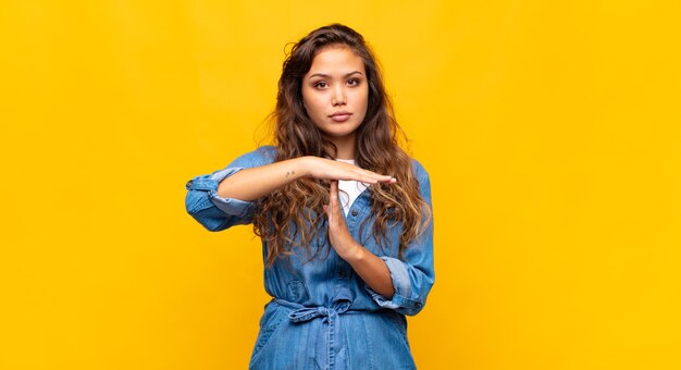 jeune jolie femme posant contre le mur coloré