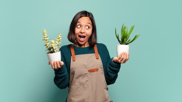 Jeune jolie femme avec des pots de cactus