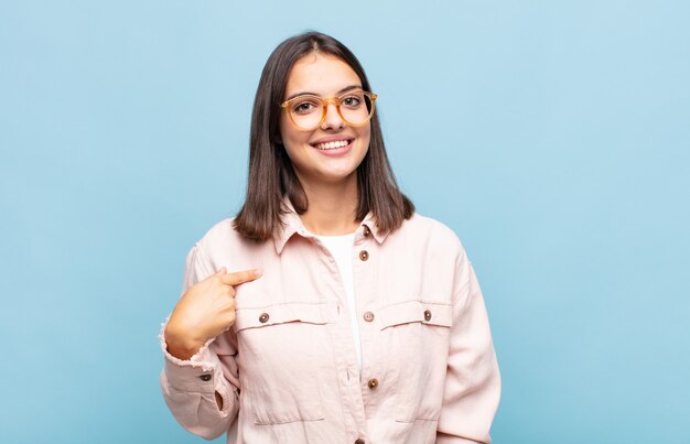 Jeune jolie femme à la recherche de bonheur, fier et surpris